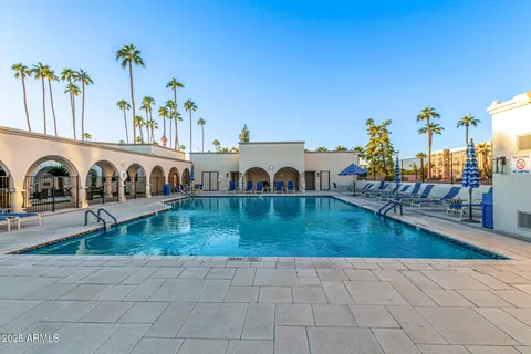 an view of a swimming pool with a lounge chair and a swimming pool