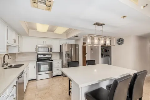 a kitchen with stainless steel appliances a sink a stove top oven a refrigerator and cabinets