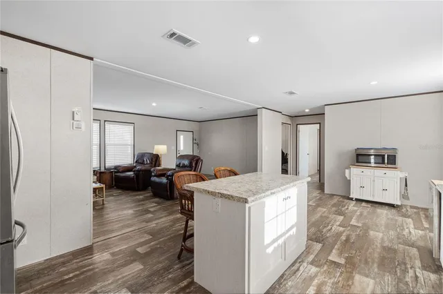 a large white kitchen with sink and refrigerator