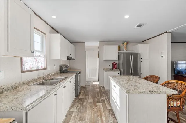 a kitchen with granite countertop a sink and a refrigerator