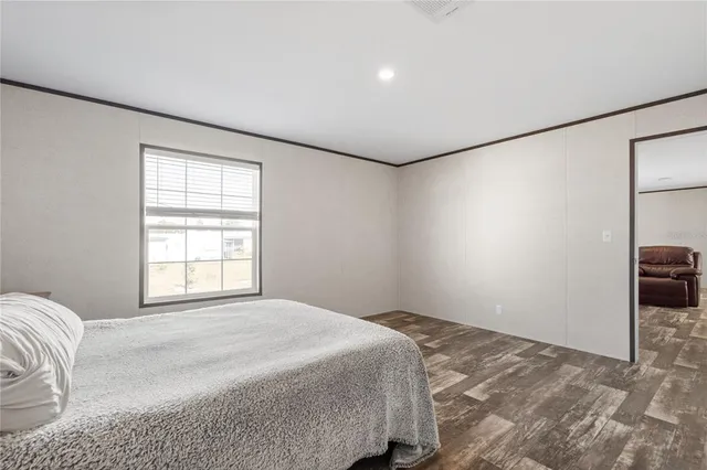 a bedroom with a bed and a large window