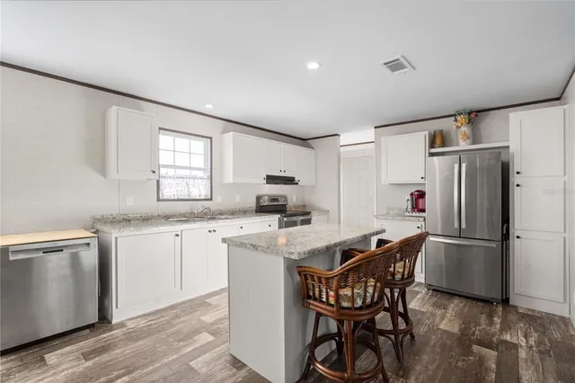 a kitchen with a table chairs refrigerator and microwave