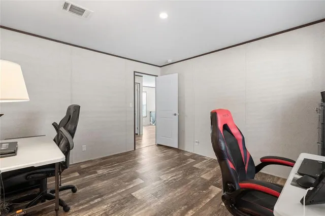 a view of a workspace with furniture and wooden floor