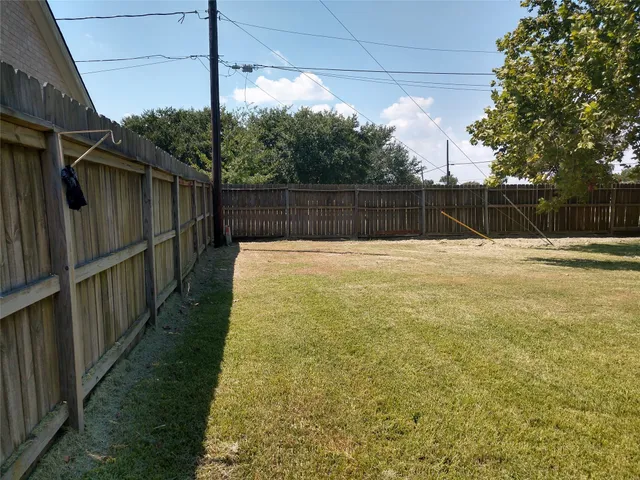a view of backyard with wooden fence