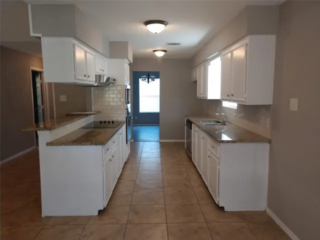 a kitchen with stainless steel appliances a sink stove and cabinets
