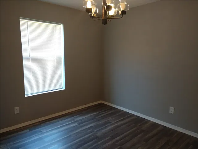a view of a room with wooden floor and windows in it