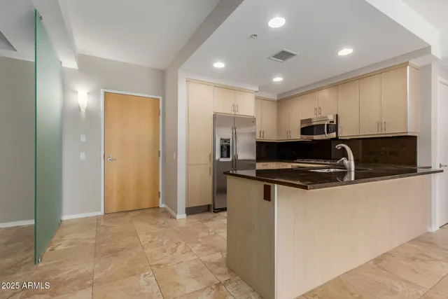 a view of kitchen with stainless steel appliances granite countertop a refrigerator and a sink