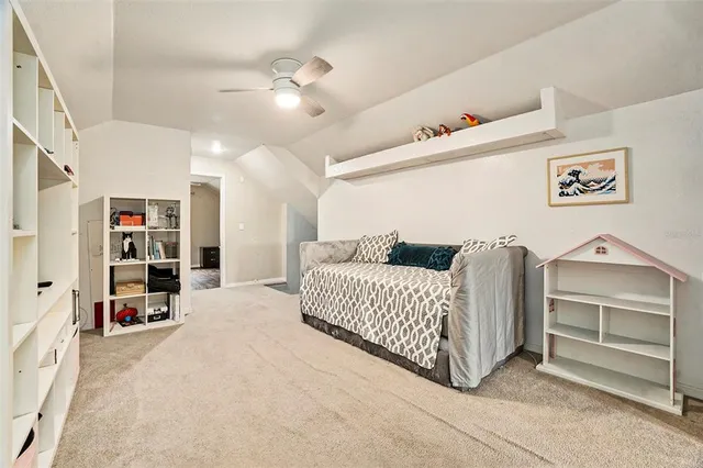 a spacious bedroom with a bed and a chandelier