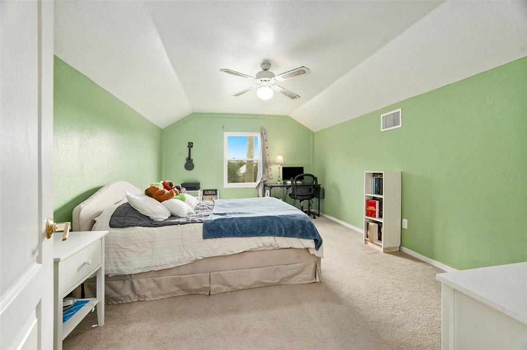 7309 Quail Meadow Road Plant City, FL 33565 - Photo 19 of 24 a spacious bedroom with a bed and a chandelier