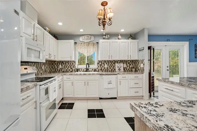 a kitchen with stainless steel appliances kitchen island granite countertop a refrigerator and a sink