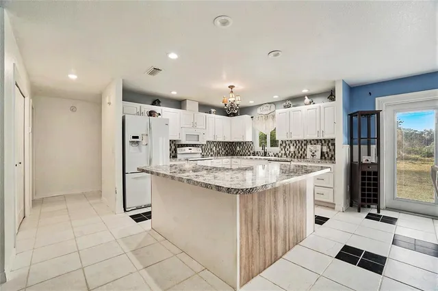 a kitchen with stainless steel appliances kitchen island granite countertop a sink and cabinets
