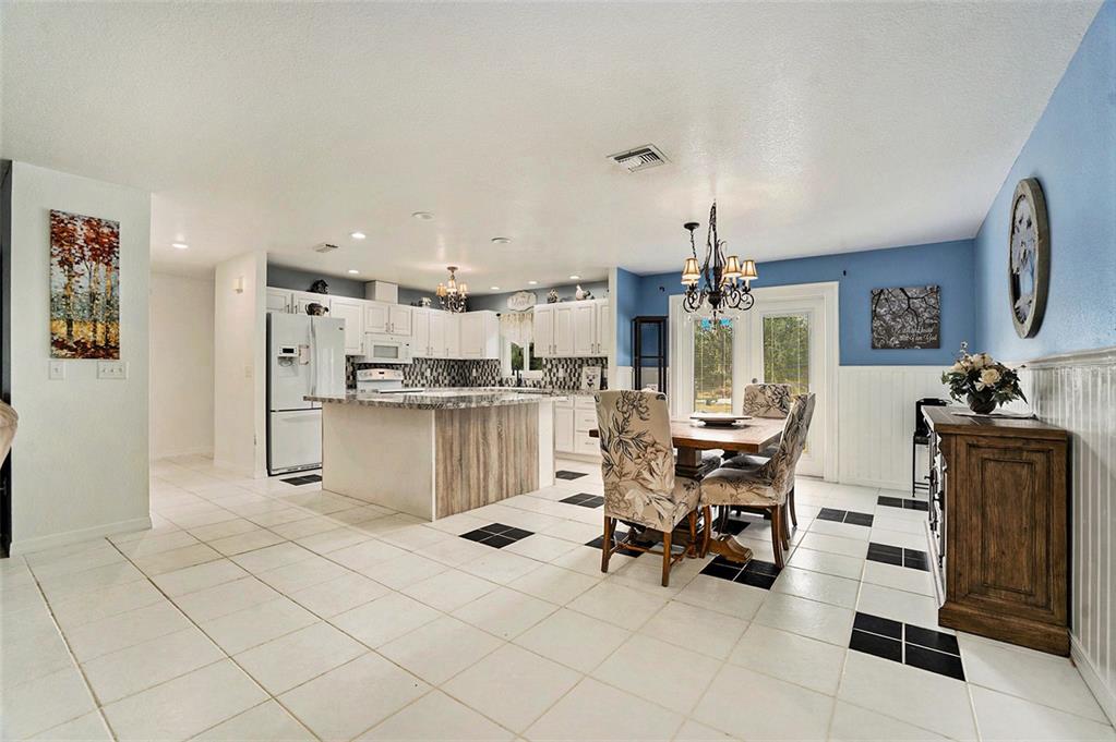 7309 Quail Meadow Road Plant City, FL 33565 - Photo 6 of 24 a kitchen with stainless steel appliances kitchen island granite countertop a sink and cabinets