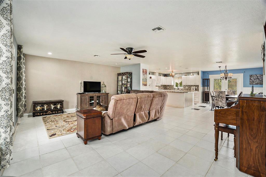 7309 Quail Meadow Road Plant City, FL 33565 - Photo 8 of 24 a living room with furniture kitchen view and a flat screen tv