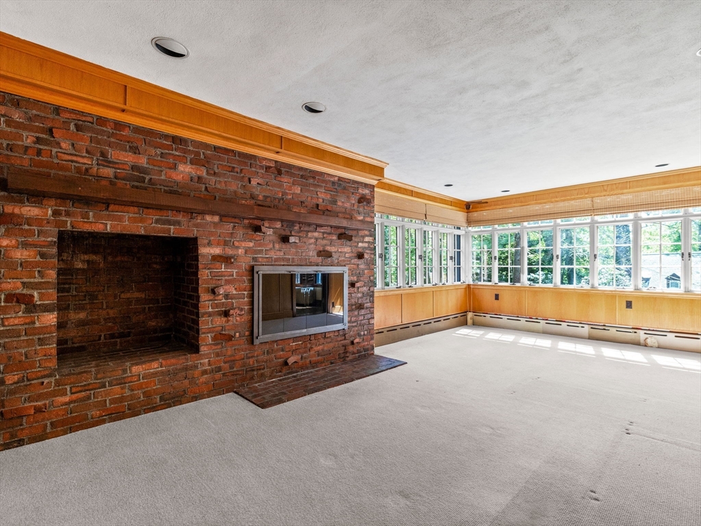 81 Garden Road Wellesley, MA 02481 - Photo 8 of 17 a view of an empty room with a fireplace and a window