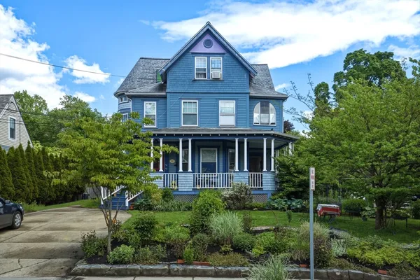 a front view of a house with a yard and potted plants
