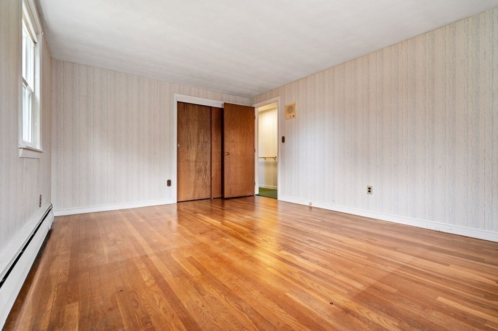 11 Christopher Drive Milton, MA 02186 - Photo 14 of 34 a view of an empty room with wooden floor and a window