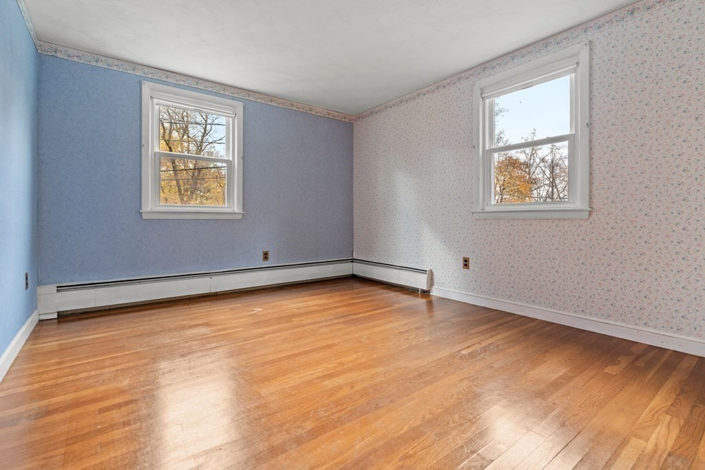 11 Christopher Drive Milton, MA 02186 - Photo 16 of 34 a view of an empty room with wooden floor and a window