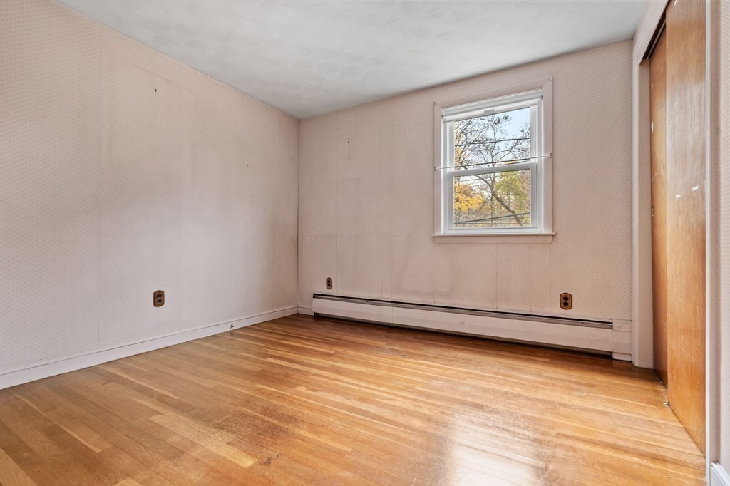 11 Christopher Drive Milton, MA 02186 - Photo 18 of 34 a view of an empty room with wooden floor and a window