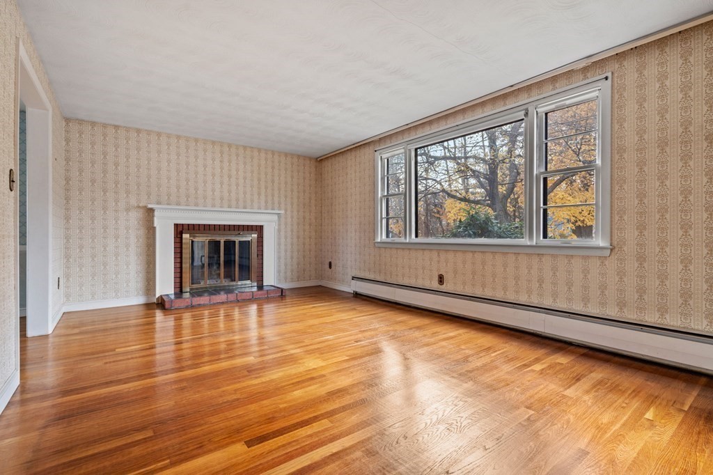 11 Christopher Drive Milton, MA 02186 - Photo 4 of 34 wooden floor fireplace and windows in an empty room