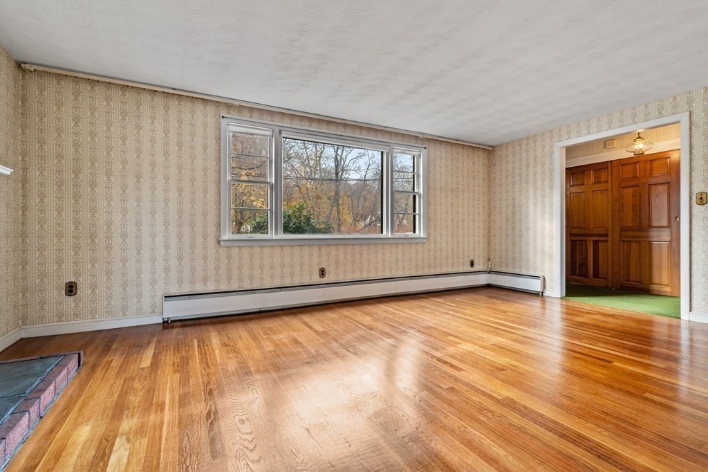 11 Christopher Drive Milton, MA 02186 - Photo 5 of 34 a view of an empty room with wooden floor and a window