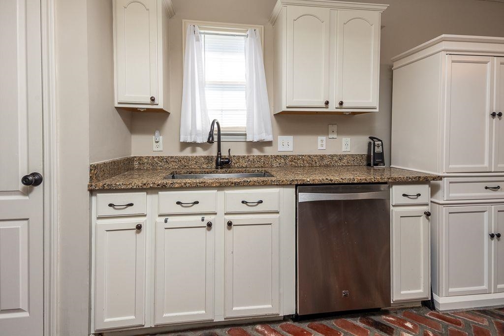 9768 Riggin Drive Memphis, TN 38002 - Photo 7 of 32 Kitchen area featuring white cabinetry, a stainless-steel dishwasher, and a dark bronze faucet