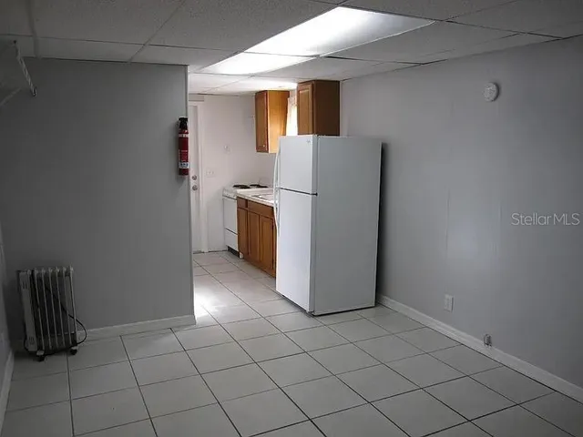 a view of kitchen with refrigerator and window