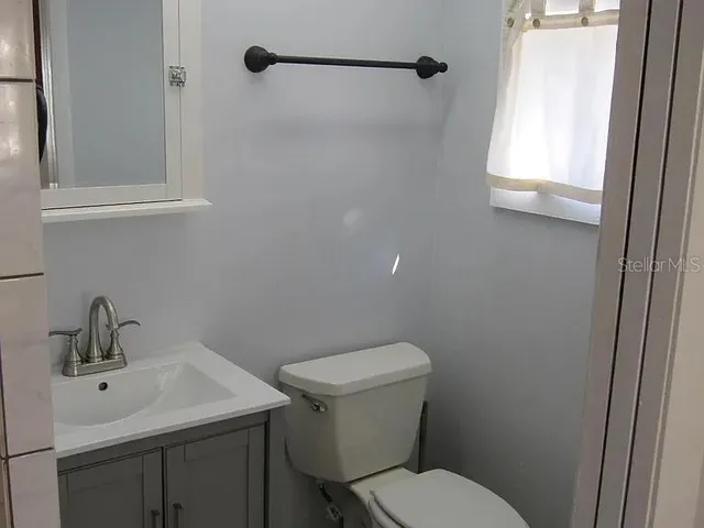 a bathroom with a toilet sink and mirror