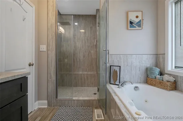 a bathroom with a tub a sink and glass door