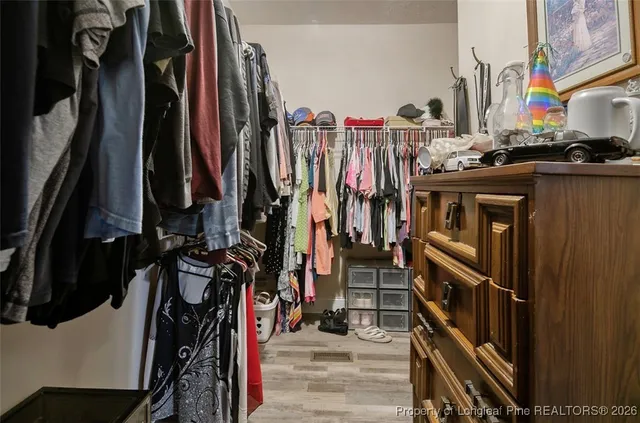 a view of walk in closet with clothes and shoes