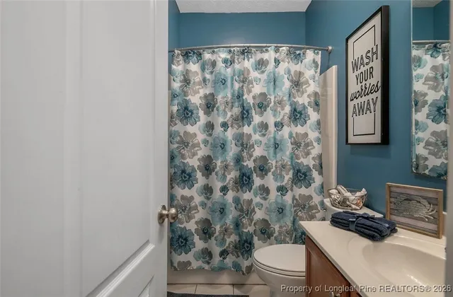a bathroom with a toilet and a shower curtain