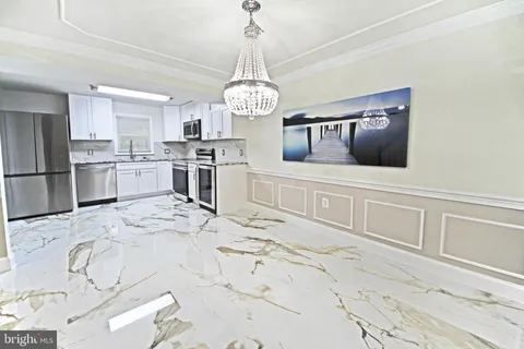 a view of a kitchen with kitchen island dining table and stainless steel appliances