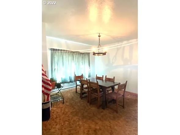 a view of a dining room with furniture and chandelier