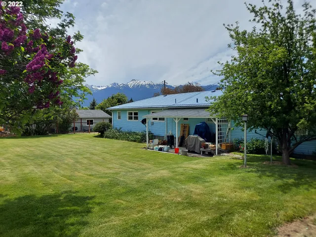 a view of a big room with table and chairs under an umbrella