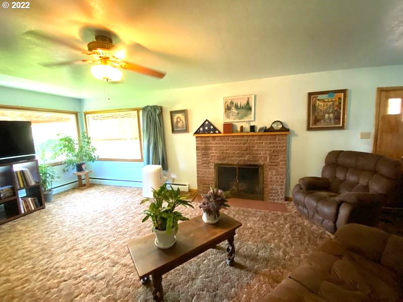 303 Northeast 2nd Street Enterprise, OR 97828 - Photo 2 of 19 a living room with furniture a fireplace and a flat screen tv