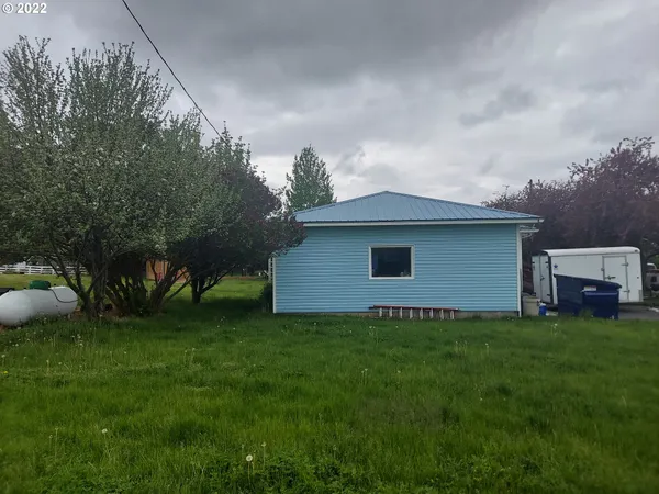 a backyard of a house with lots of green space and trampoline