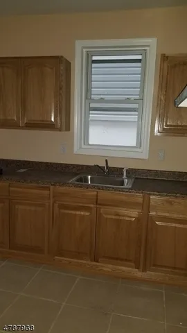a kitchen with granite countertop a sink and a stove