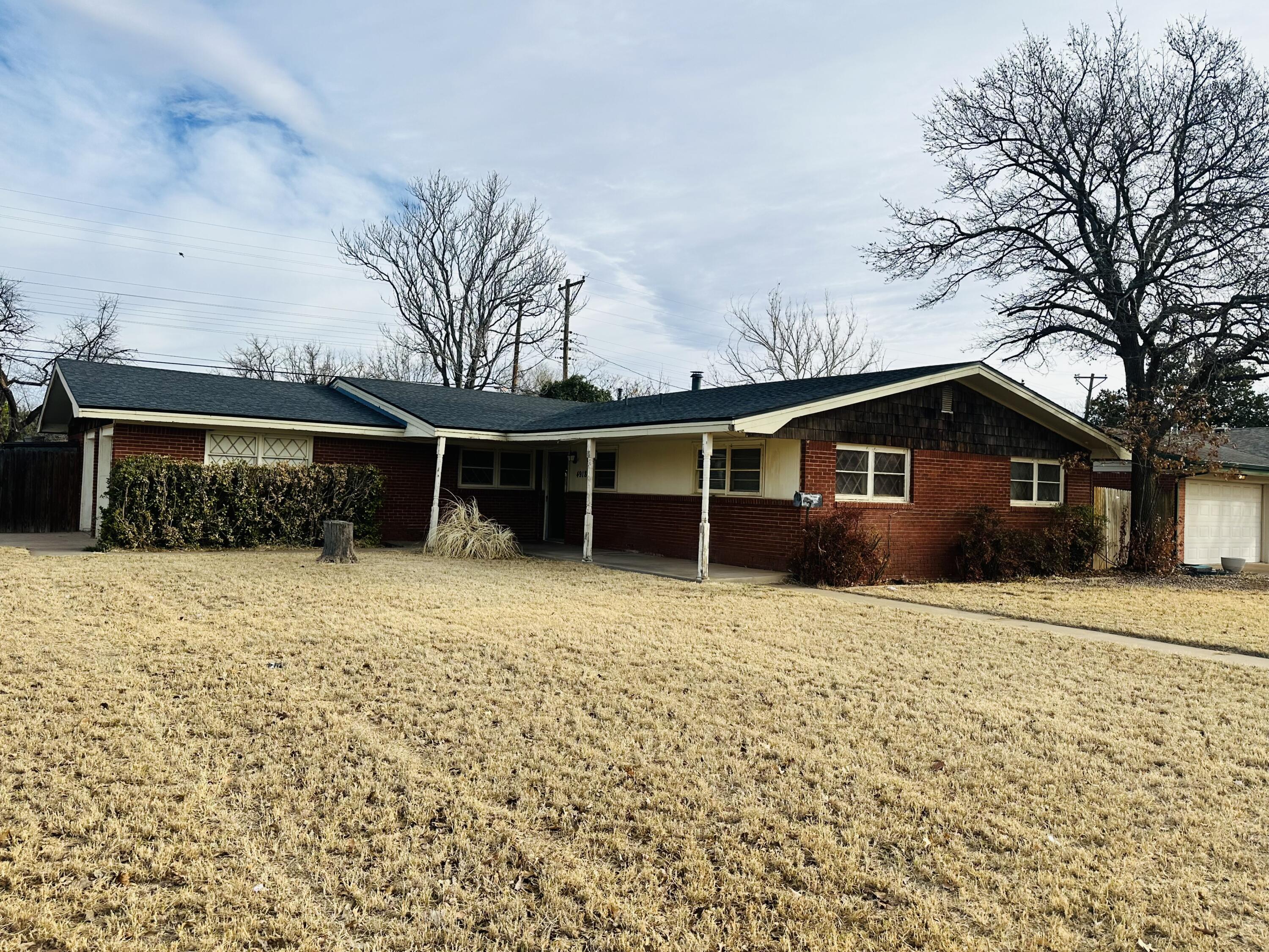 4918 14th Street Lubbock, TX 79416 - Photo 1 of 38 a front view of a house with a yard and garage