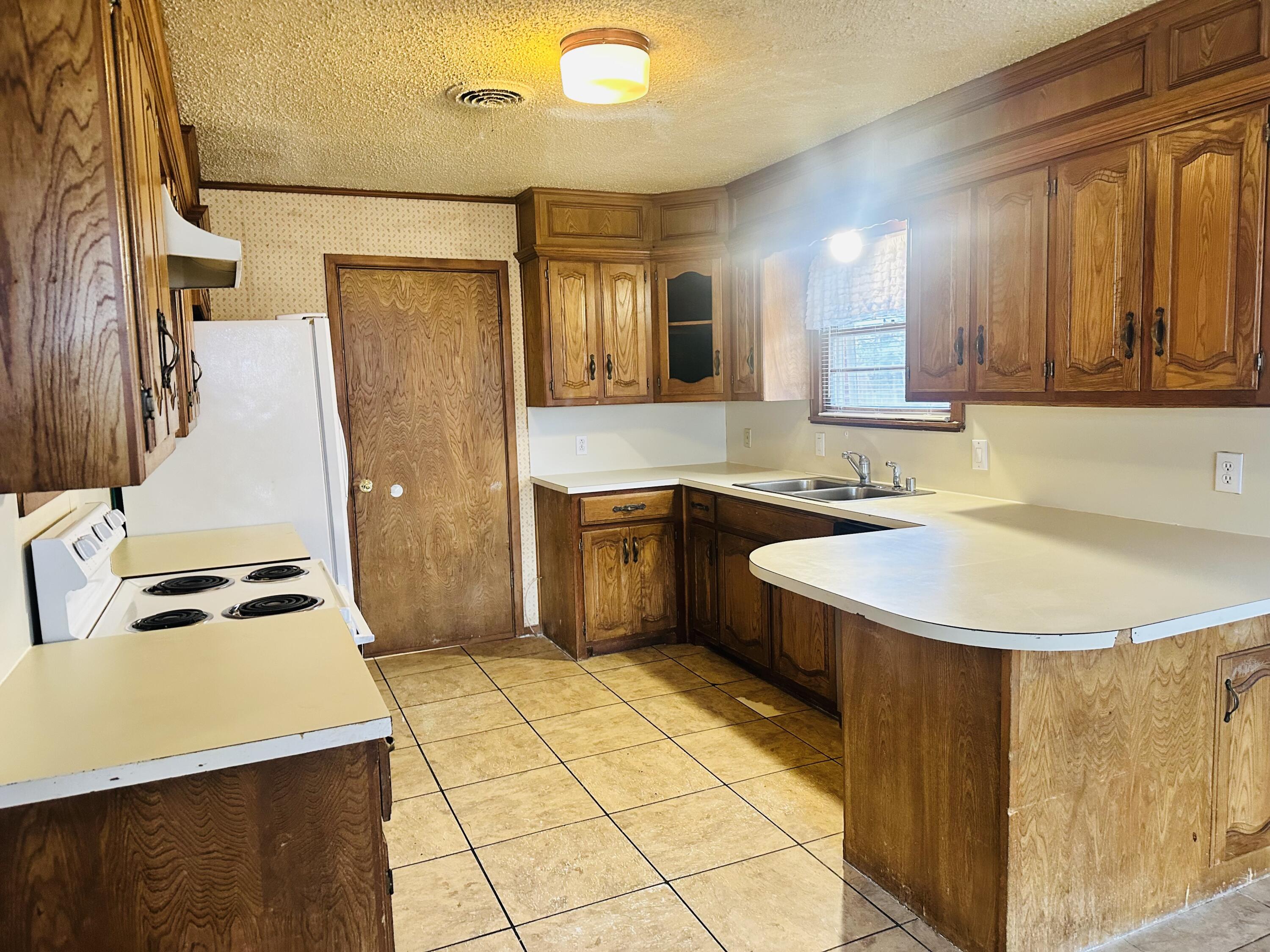 4918 14th Street Lubbock, TX 79416 - Photo 19 of 38 a kitchen with a sink a stove top oven and cabinetry