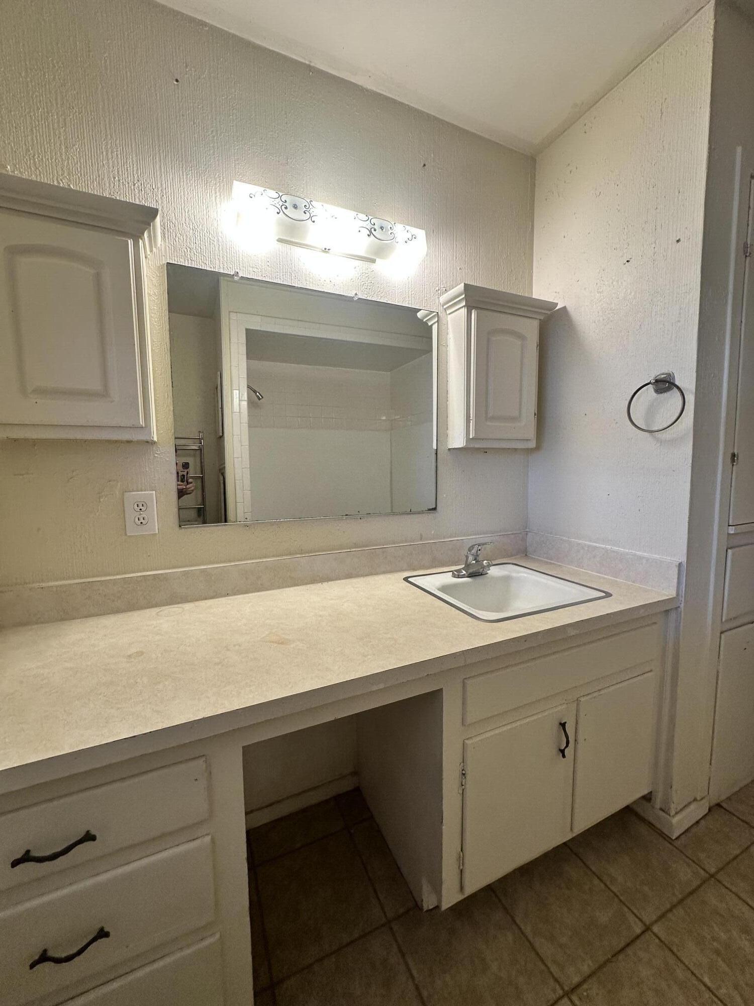 4918 14th Street Lubbock, TX 79416 - Photo 24 of 38 a bathroom with a sink and a mirror