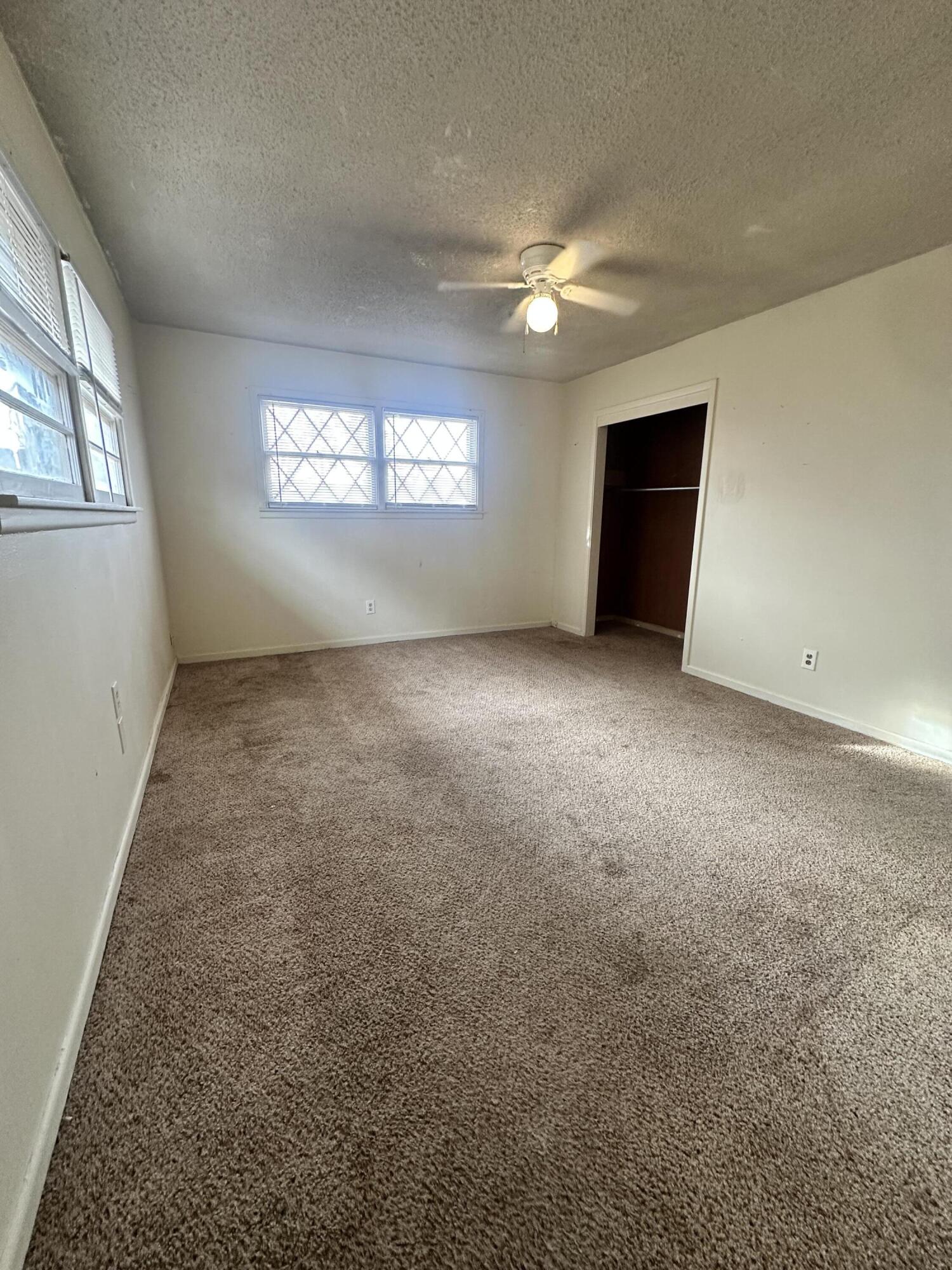 4918 14th Street Lubbock, TX 79416 - Photo 31 of 38 an empty room with windows and closet