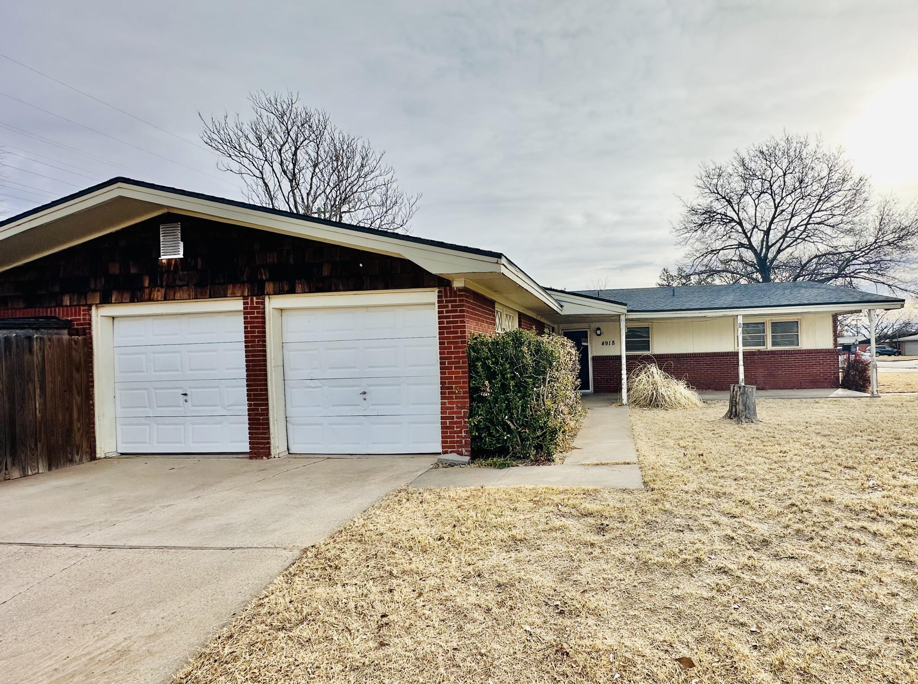 4918 14th Street Lubbock, TX 79416 - Photo 5 of 38 a front view of a house with a yard and garage