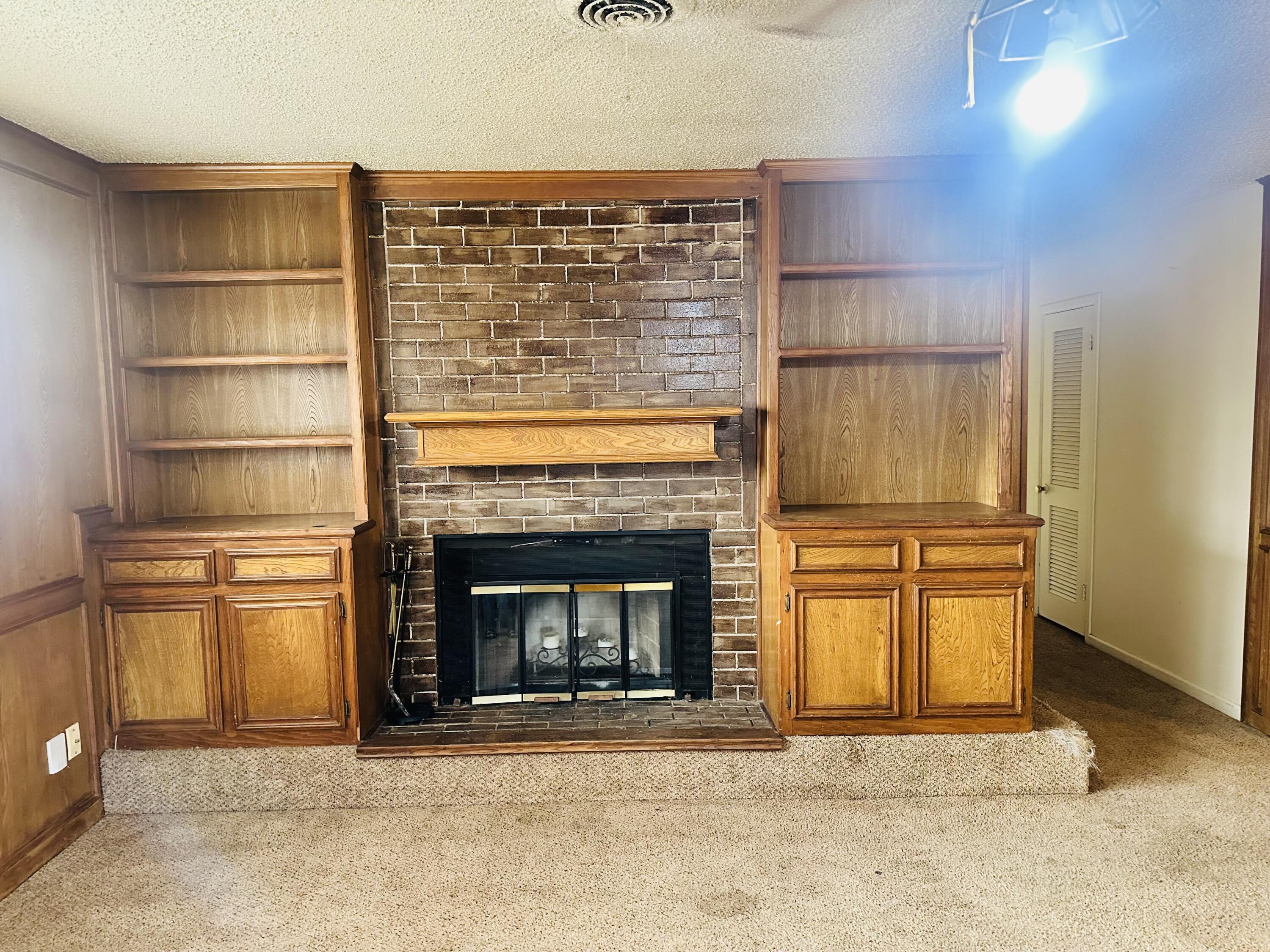 4918 14th Street Lubbock, TX 79416 - Photo 9 of 38 a view of an empty room with a fireplace and a window