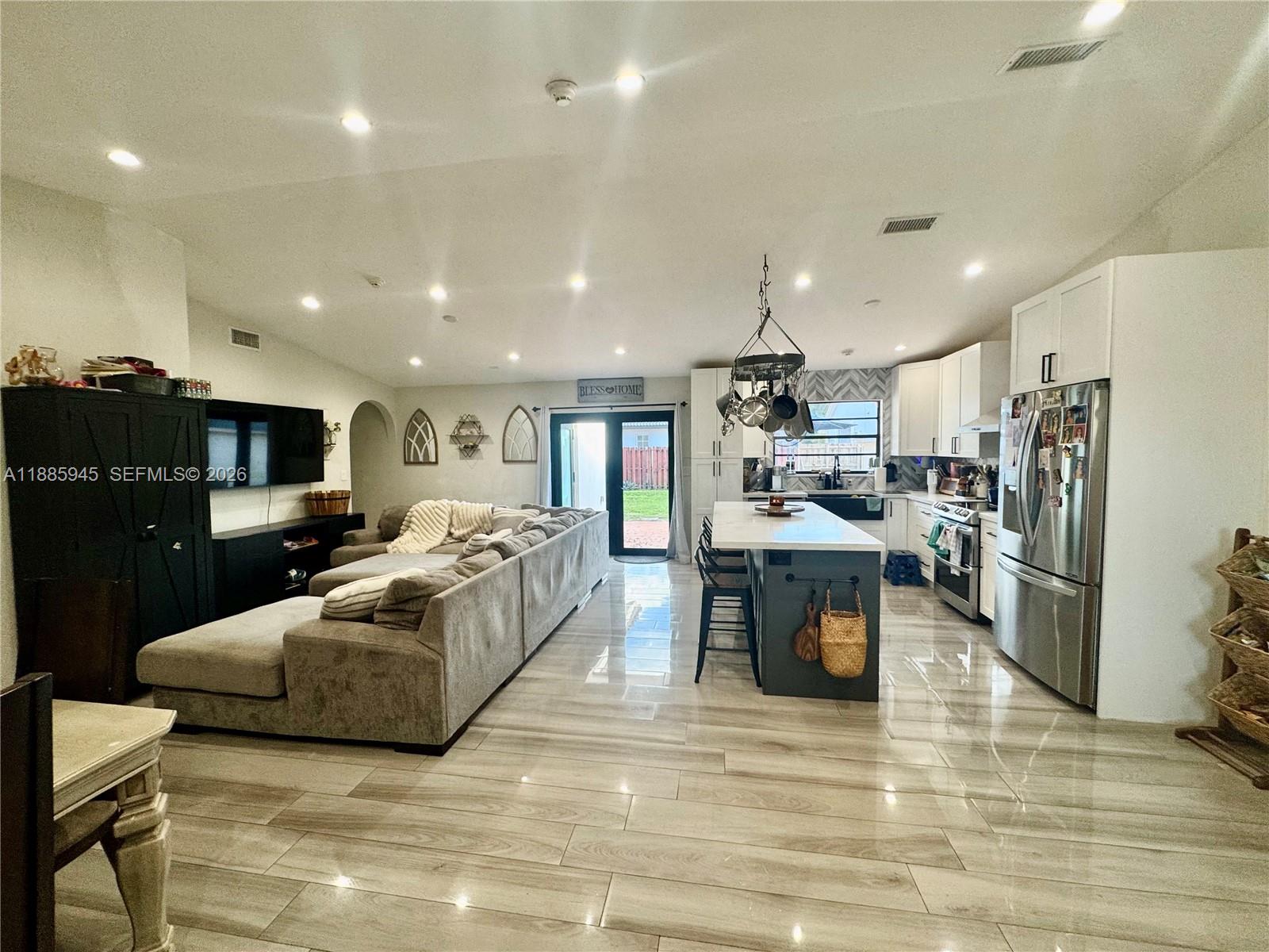 a large white kitchen with a large window a stove and a refrigerator