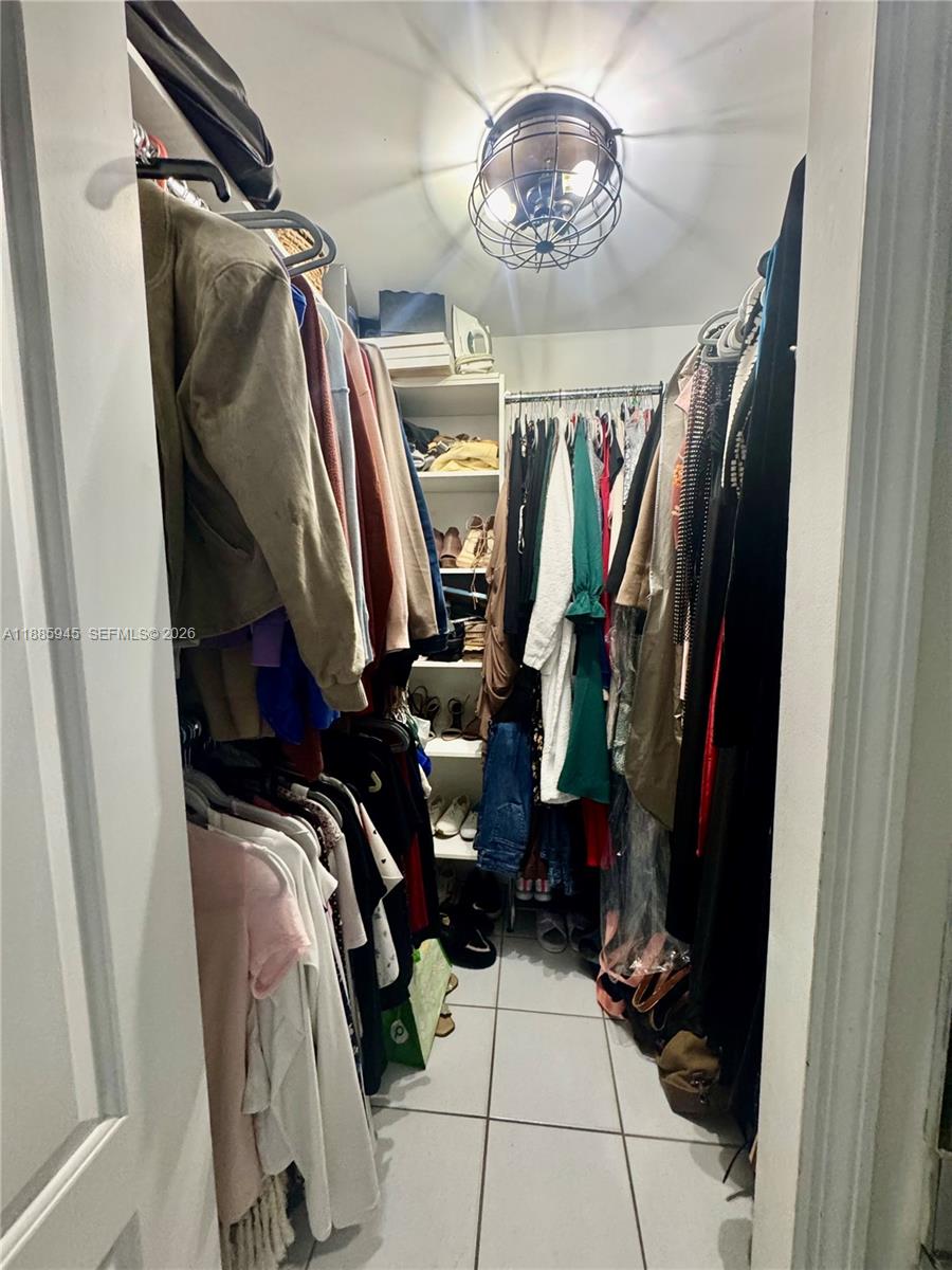 11178 Southwest 74th Terrace Miami, FL 33173 - Photo 16 of 18 a view of walk in closet with clothes and shoes
