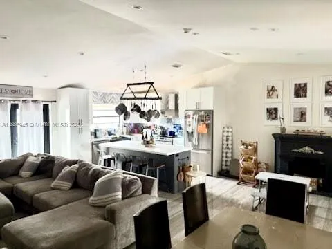 a living room with furniture kitchen view and a window