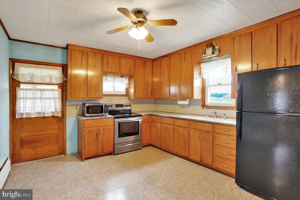 238 Grim Road Kutztown, PA 19530 - Photo 7 of 32 a kitchen with stainless steel appliances granite countertop a refrigerator a sink dishwasher a stove top oven a washer and dryer with wooden floor