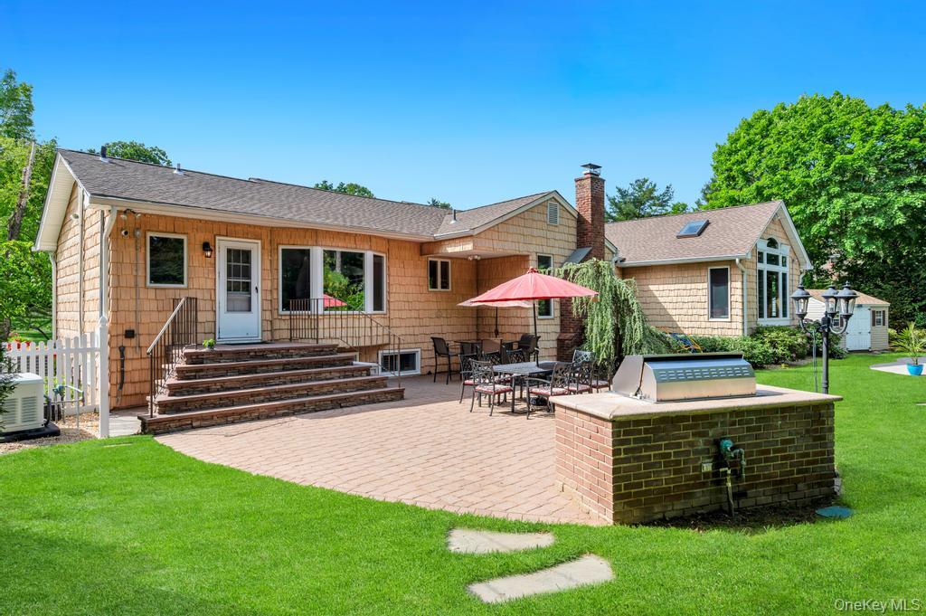 10 South Lot Road Smithtown, NY 11787 - Photo 38 of 50 Expansive paver patio with a built-in brick grilling station, complemented by a large green lawn