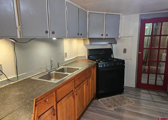 a kitchen with granite countertop a sink and a stove
