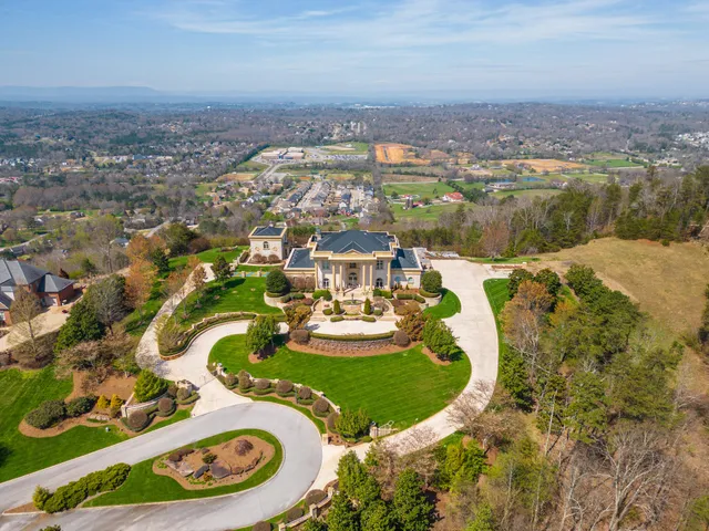 an aerial view of a house with yard swimming pool and green space