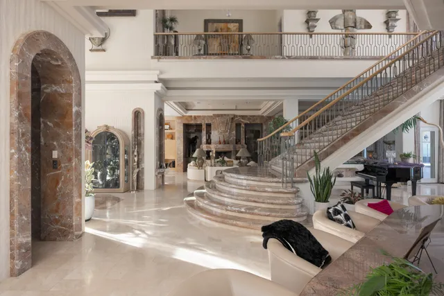 a bedroom with a large bed and a chandelier